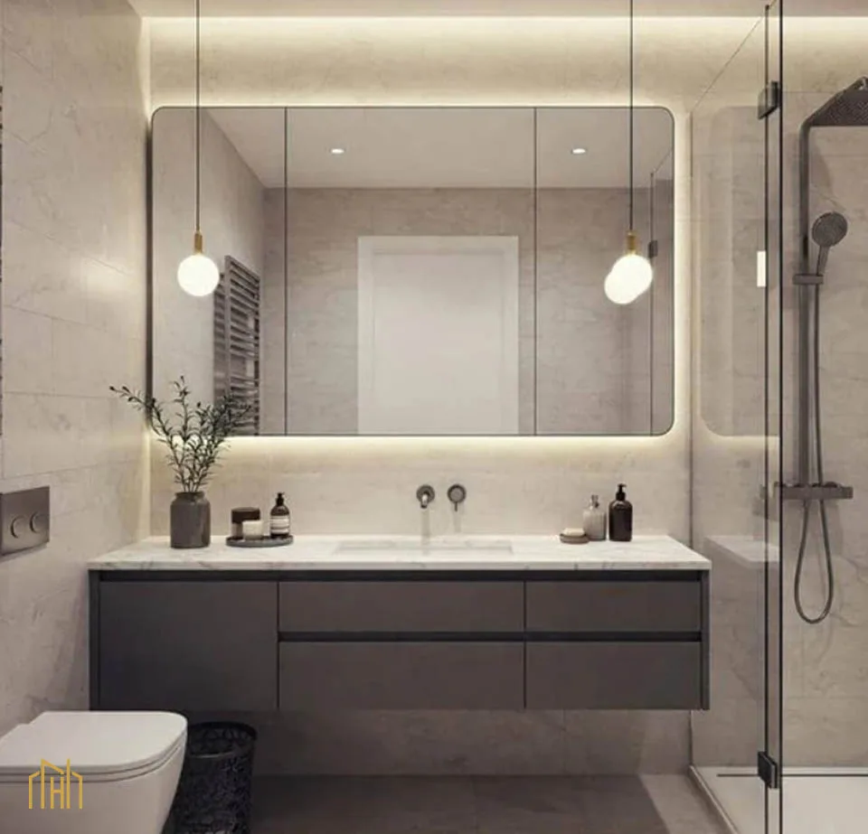 Large frameless mirror and unified floor-to-shower tile maximizing visual space in a small Plano bathroom remodel.