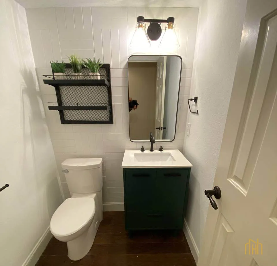 White floating vanity maximizing floor space in a small townhome bathroom, paired with slim vertical storage units.