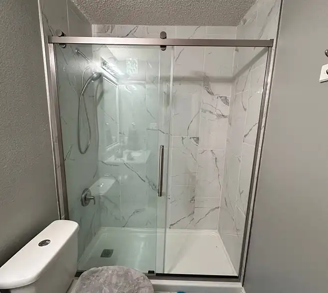 Modern walk-in shower with elegant large-format porcelain tiles.