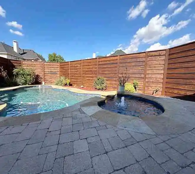 Backyard with new wood privacy fence and stone base installation in Plano, TX