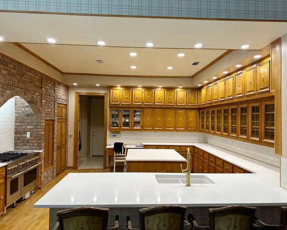 Modern remodeled kitchen in Plano, TX featuring new custom cabinets, redesigned stove wall, upgraded island, and premium countertops