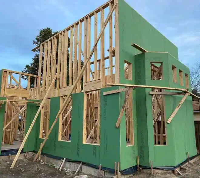 Green wood house framing under construction showing structural wall framing